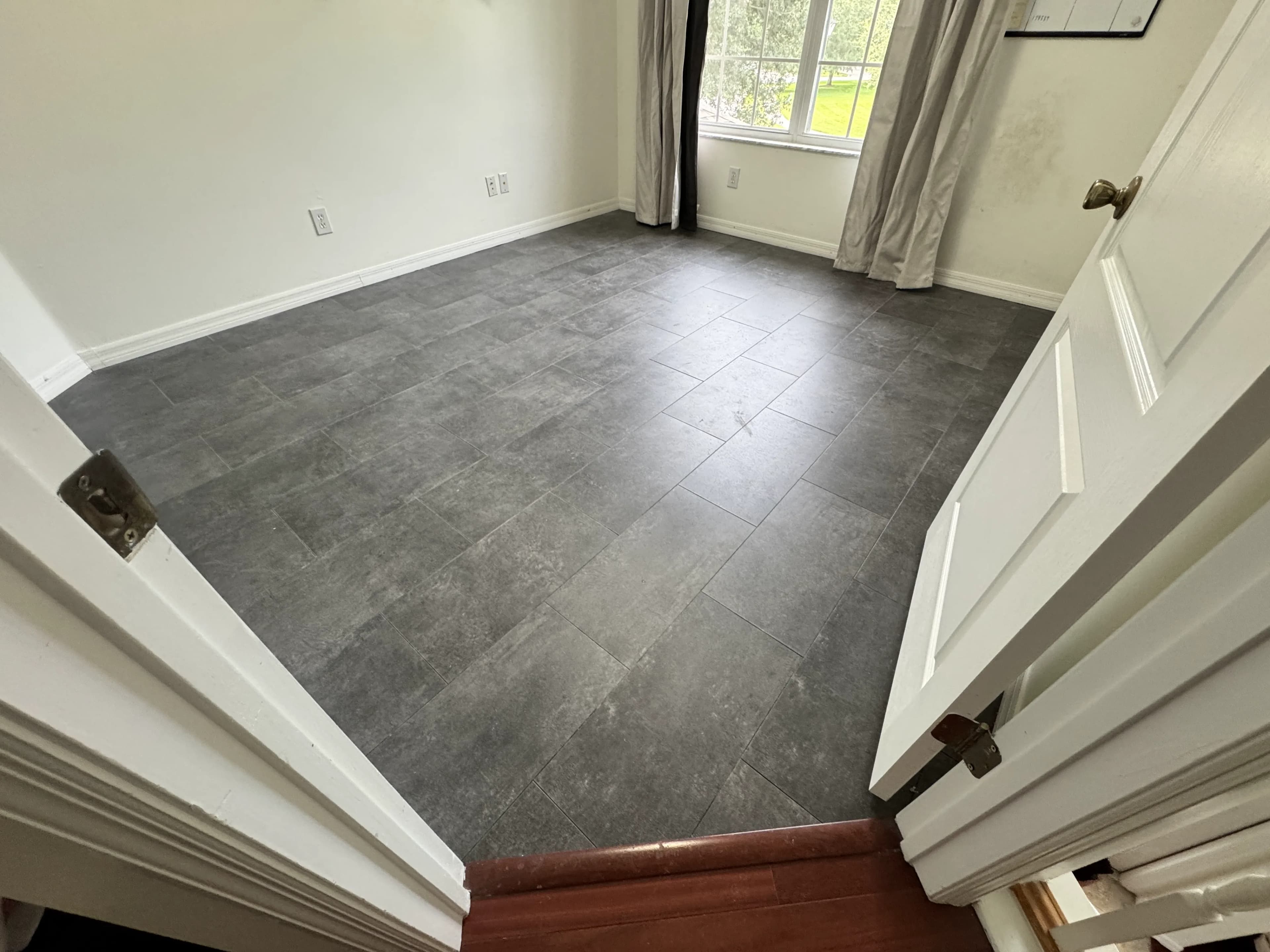 Dark rectangular floor tiles in a bright room