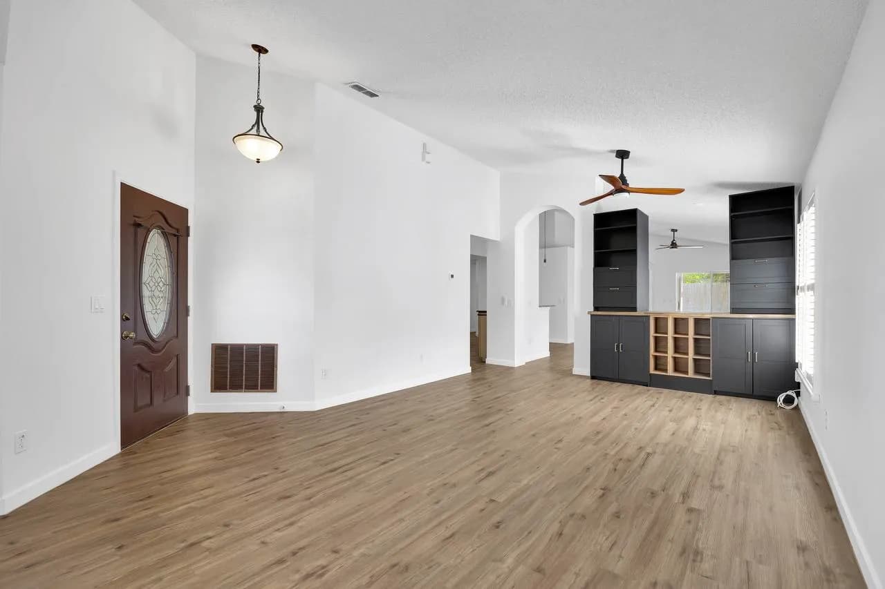 Bright living room with white walls and dark accent cabinetry